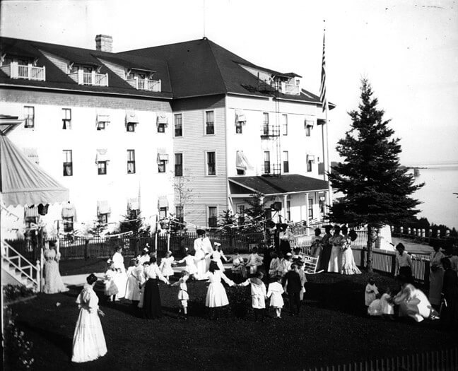 An old black and white photo of women and children playing outdoors