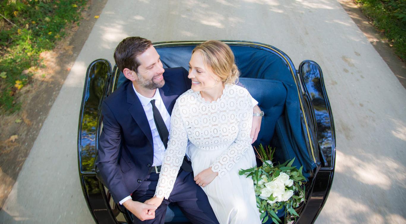 A couple sitting in a carriage on their wedding day
