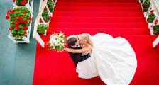 A top-view married couple kissing at the top of the steps