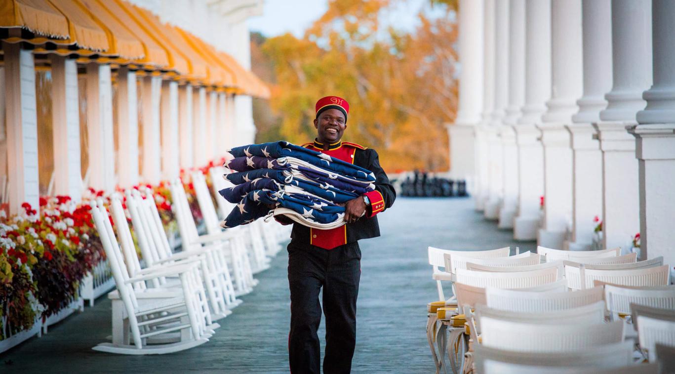 A bellman carrying American flags