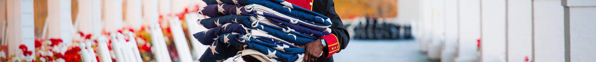 A bellman carrying American flags