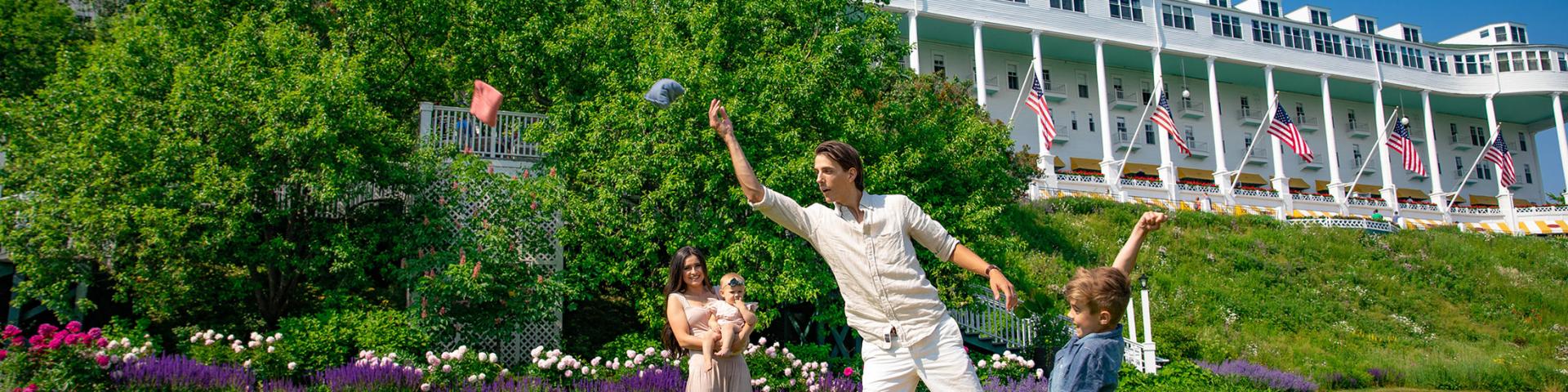 A family playing cornhole on the lawn
