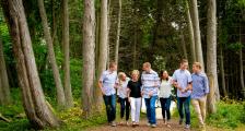Family linking arms walking through the woods