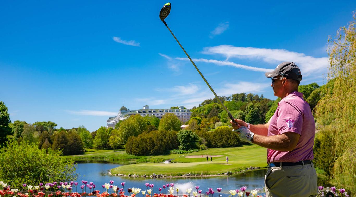 Plan golfing near pond with Grand Hotel in far background