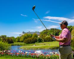 Plan golfing near pond with Grand Hotel in far background