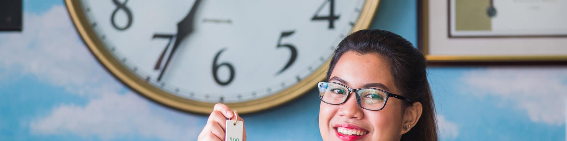 Lady at front desk reception giving someone a room key