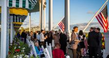 Large group of people mingling on the front porch of Grand Hotel