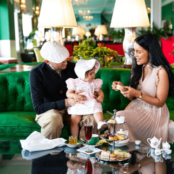 Mother and Father with child sitting on couch in Grand Hotel
