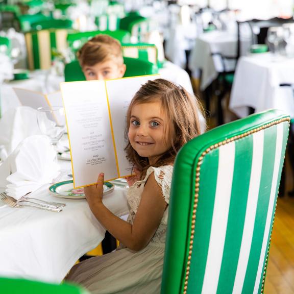girl holding menu at dinner table