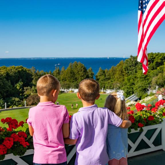 Three kids looking at the lake from front porch