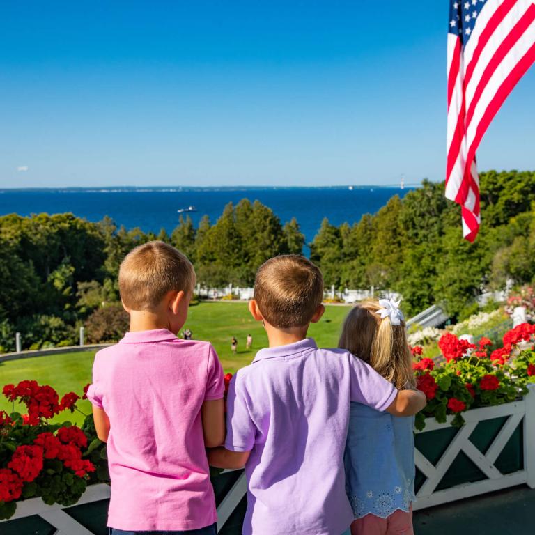 Three kids looking at the lake from front porch