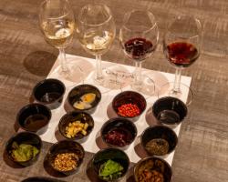 A unique food and wine pairing experience at the Grand Hotel's 'Cork & Fork' event, featuring a flight of wines and various small bites for a sensory tasting.