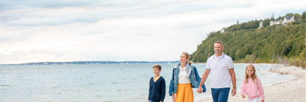 A family enjoys a memorable walk along the shores of Lake Huron during their vacation at Grand Hotel on Mackinac Island.