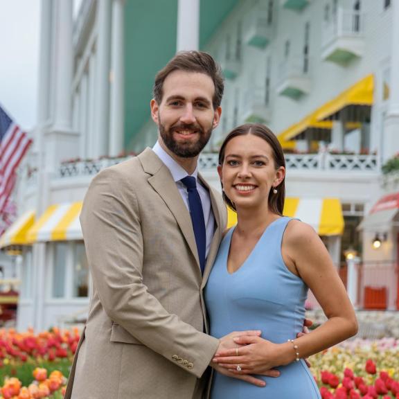 Couple in front of Grand Hotel. Flags in the background.
